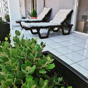 a patio with two chairs and plants on a porch at Elli's House in Keramotí