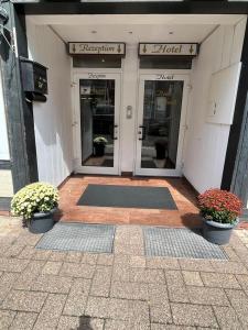 a building with two entrances to a hotel with two plants at Hotel zur Altstadt in Celle