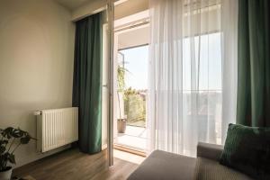 a living room with a large window with green curtains at Nowy w centrum in Giżycko