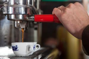 una persona está haciendo una taza de café en Hotel Donatello, en Alberobello