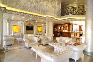 a large room with white couches and tables in a building at Hotel & SPA Diamant Residence - All Inclusive in Sunny Beach