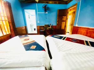 two beds sitting next to each other in a room at Peace Home in Sa Pa