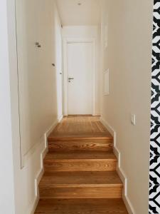 a hallway with wooden floors and a white door at Baixa-Mar Setúbal Miradouro in Setúbal