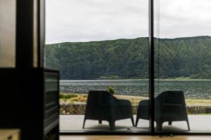 twee stoelen en een tafel met uitzicht op een meer bij Sete Cidades Lake Cabin - Casa da Lagoa in Ponta Delgada