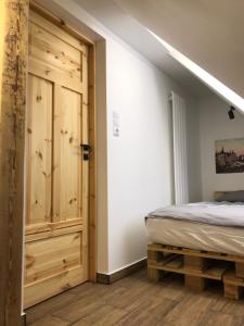 - une chambre avec un lit et une porte en bois dans l'établissement Nowe miasto, à Wałbrzych