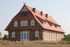 een groot houten huis met een rood dak bij Landhaus Fünfseen in Funfseen