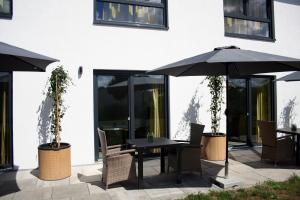 einen Tisch und Stühle mit Sonnenschirm auf einer Terrasse in der Unterkunft Hotel HeideZeiten in Walsrode