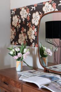 un espejo sentado en una mesa de madera con flores en Boutique Hotel Galatea, en Roma