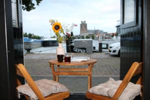 een tafel en stoelen met een vaas met bloemen op een patio bij B&B verDRAAId fijn in Dordrecht