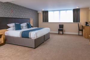 Best Western Northfields Ealing Hotel في لندن: غرفة الفندق بسرير كبير ومكتب