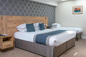 Best Western Northfields Ealing Hotel في لندن: غرفة نوم بسريرين و اللوح الأمامي خشبي