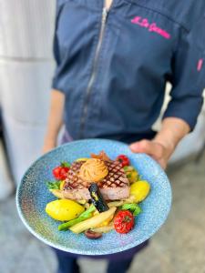 une personne détenant une assiette de denrées alimentaires contenant des fruits et légumes dans l'établissement Star-Apart Hansa Hotel, à Wiesbaden