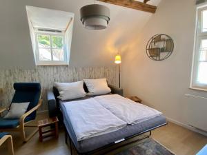 una camera con letto e sedia blu di Gästehaus Rheinromantik a Bacharach