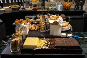 a counter with a bunch of pastries and other food at Hotel Ancora in Verbania