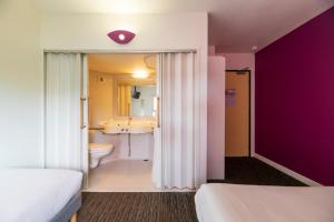 Cette chambre comprend une salle de bains pourvue d'un lavabo et de toilettes. dans l'établissement Hôtel Cerise Auxerre, à Monéteau