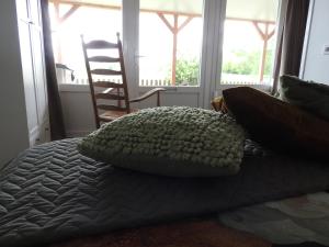 1 cama con almohada en una habitación con ventanas en Bed & Breakfast Boszicht Leeuwarden, en Leeuwarden