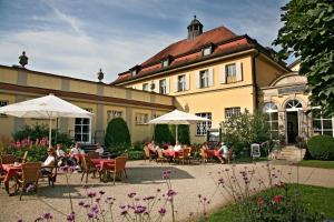 un gruppo di persone seduti ai tavoli di fronte a un edificio di Badhotel Bad Brückenau a Staatsbad Brückenau