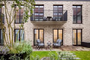 a brick building with two chairs and a table on a deck at Lux Apartment With A Terrace In Vilnius Old Town in Vilnius