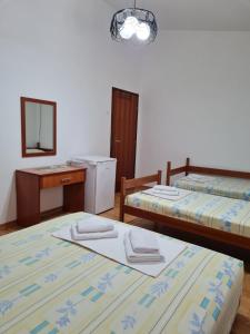 a room with two beds and a sink and a mirror at Castello Apartments in Ulcinj