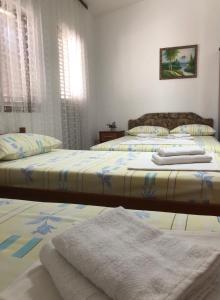 two beds in a bedroom with towels on them at Castello Apartments in Ulcinj