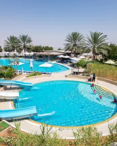 una grande piscina con acqua blu in un resort di Mercure Grand Jebel Hafeet Hotel a Al Ain