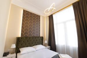 Un pat sau paturi într-o cameră la Modern Revival Luxury Hotel