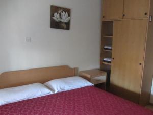 een slaapkamer met een bed met een rode sprei bij Rooms Pri Lovrižu in Kobarid