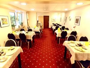 een eetkamer met tafels en stoelen met witte tafelkleden bij Hotel zur Post in Herne