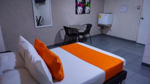 - une chambre avec un lit, une table et des chaises dans l'établissement Casa Boston Inn, à Barranquilla