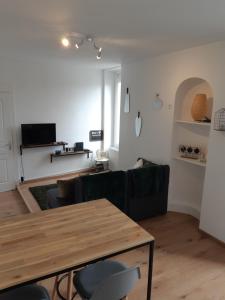 - un salon avec une table et un canapé dans l'établissement Cosy T2 31m2 - Centre-Ville Dijon - Gare et Darcy, à Dijon