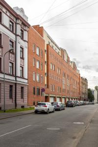 een straat met auto's geparkeerd voor gebouwen bij Jekabpils 2 Apartment in Rīga