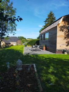 une arrière-cour avec une table de pique-nique et un bâtiment dans l'établissement Tiny Messancy, une immersion dans la nature !, à Messancy