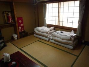 una stanza con un mucchio di asciugamani sul pavimento di Daiya Ryokan a Kyoto