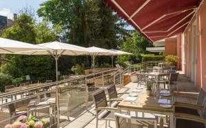 un ristorante con tavoli e ombrelloni su un patio di Hotel Oranien Wiesbaden a Wiesbaden