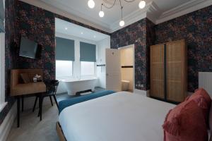 A bed or beds in a room at The Clarence Boutique Rooms