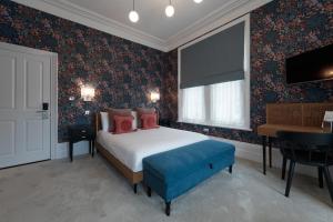 A bed or beds in a room at The Clarence Boutique Rooms