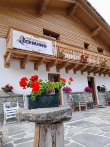 een bord aan de zijkant van een gebouw met bloemen bij Chalet Gaspard in Valtournenche