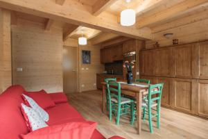 een woonkamer met een rode bank en een tafel bij Chalet Gaspard in Valtournenche