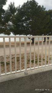 biały płot z plażą w tle w obiekcie Diklo beach apartments Robert & Renata w mieście Zadar