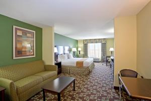 una camera d'albergo con letto e divano di Holiday Inn Express Hotel & Suites Dumas, an IHG Hotel a Dumas