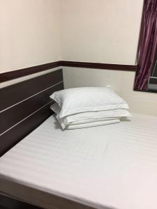 a bed with a white pillow on top of it at Hang Ho Hostel in Hong Kong