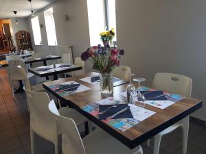 une table avec un vase de fleurs au-dessus dans l'établissement Auberge de Thelis, à Thélis-la-Combe