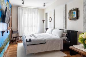 a bedroom with a white bed and a tv at Pelican Hotel in Miami Beach