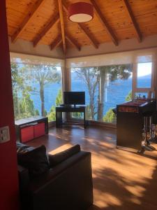 - un salon avec un canapé et un piano dans l'établissement Apartments Seeblick Bariloche, à San Carlos de Bariloche