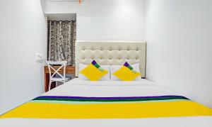 - une chambre dotée d'un lit blanc avec des oreillers jaunes et violets dans l'établissement Itsy Hotels Heraa International, à Mumbai