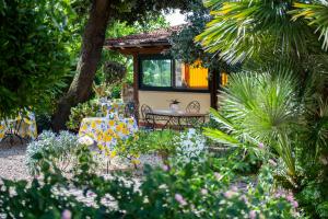 eine Terrasse mit einem Tisch und Stühlen im Garten in der Unterkunft I Lecci Guesthouse in San Felice Circeo