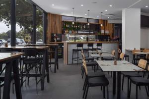 un restaurant avec des tables et des chaises ainsi qu'un bar dans l'établissement Rydges South Park Adelaide, à Adélaïde