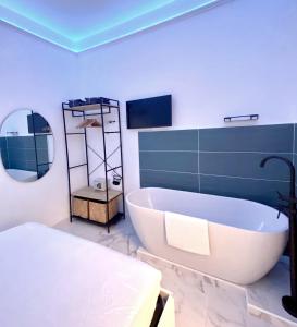 a bathroom with a tub and a bed and a mirror at The Apartment in Porto Santo Stefano