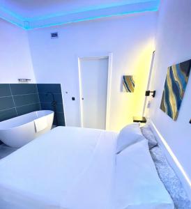 a bedroom with a white bed and a bath tub at The Apartment in Porto Santo Stefano