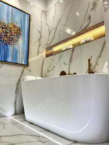 - une salle de bains blanche avec un ordinateur portable sur un comptoir dans l'établissement MONDRIAN Luxury Suites & Apartments Market Square I, à Varsovie